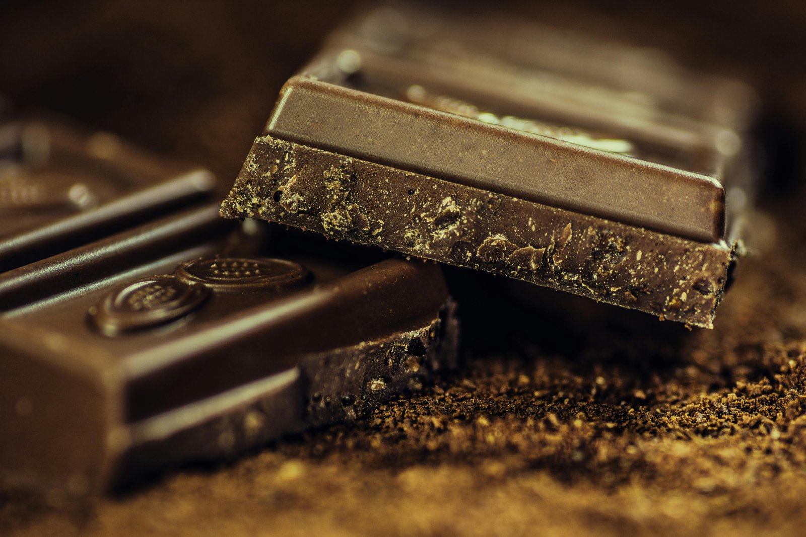 Close-up of a dark chocolate bar with textured surface and broken edges.