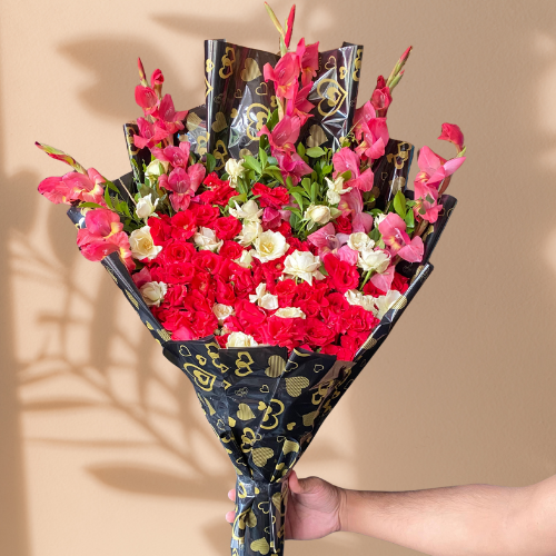 A stunning 4-foot-tall bouquet featuring red roses, pink and white gladiolus, expertly wrapped in black and gold paper. Beautiful red rose and gladiolus flower arrangement in luxurious black and gold wrapping. Tall, elegant floral bouquet with roses and gladiolus for a special occasion.