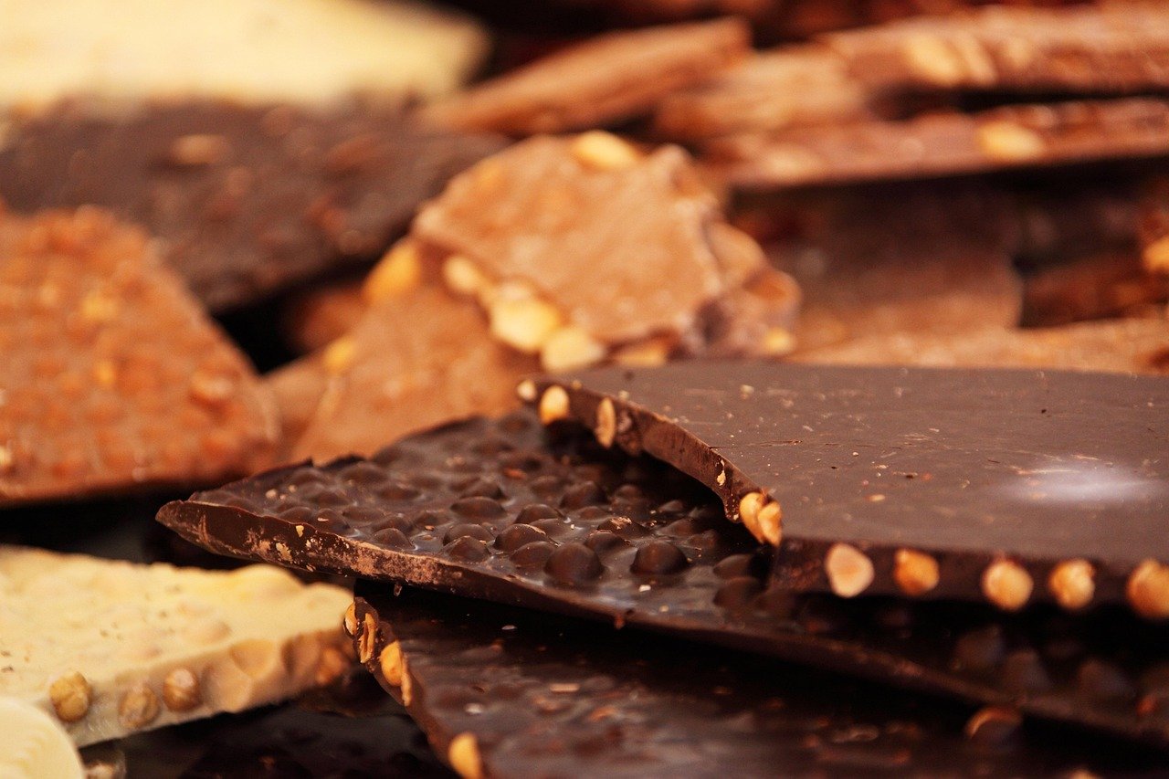 Assorted dark, milk, white, and nut-studded chocolate bars illustrating the variety of chocolate colors and types.